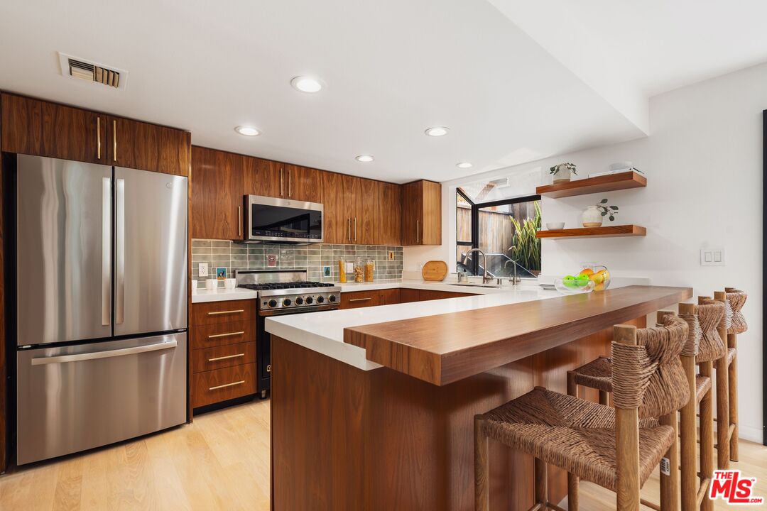 831 14th Street, Unit 2 Santa Monica, CA 90403 - Photo 10 of 32 a kitchen with kitchen island a sink appliances and cabinets