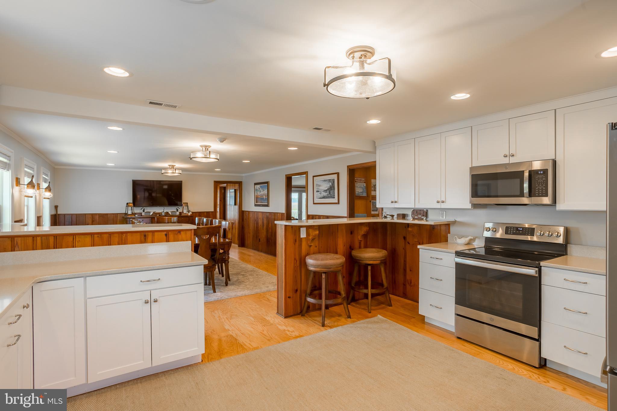 3706 Bestpitch Ferry Road Cambridge, MD 21613 - Photo 20 of 43 a living room with stainless steel appliances kitchen island granite countertop a stove top oven a sink a dining table and chairs with wooden floor