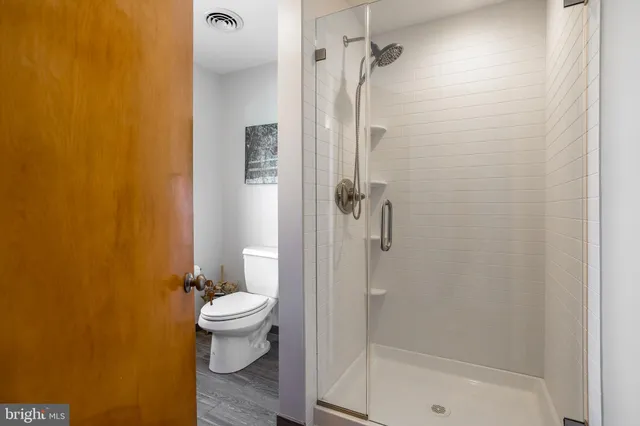 a bathroom with a toilet and a shower