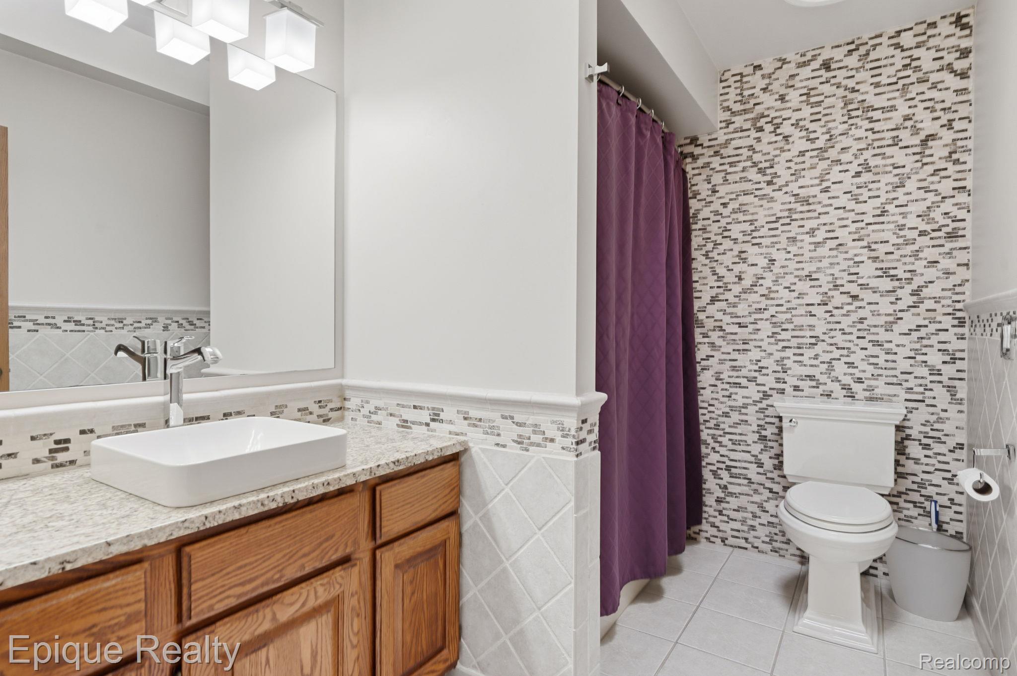 6607 Ridgeview Drive Clarkston, MI 48346 - Photo 19 of 25 Bathroom with tile walls, vanity, a shower with curtain, a wainscoted wall, and light tile patterned flooring