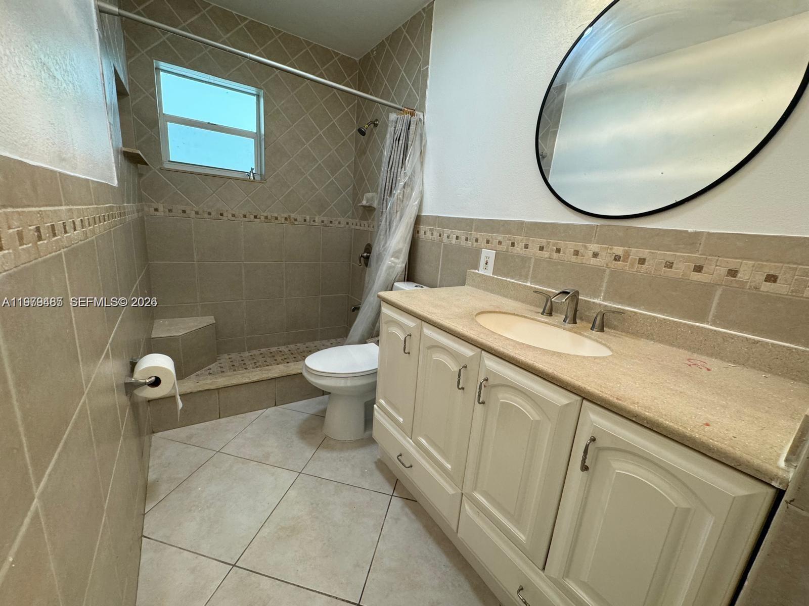 3340 Southwest 94th Place, Unit 1 Miami, FL 33165 - Photo 12 of 21 a bathroom with a sink a toilet and a mirror