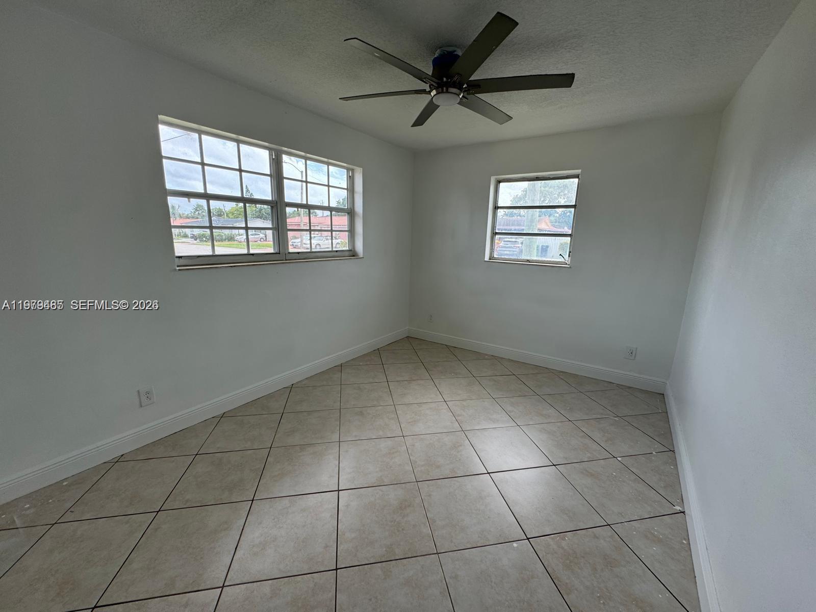 3340 Southwest 94th Place, Unit 1 Miami, FL 33165 - Photo 14 of 21 an empty room with windows and ceiling fan