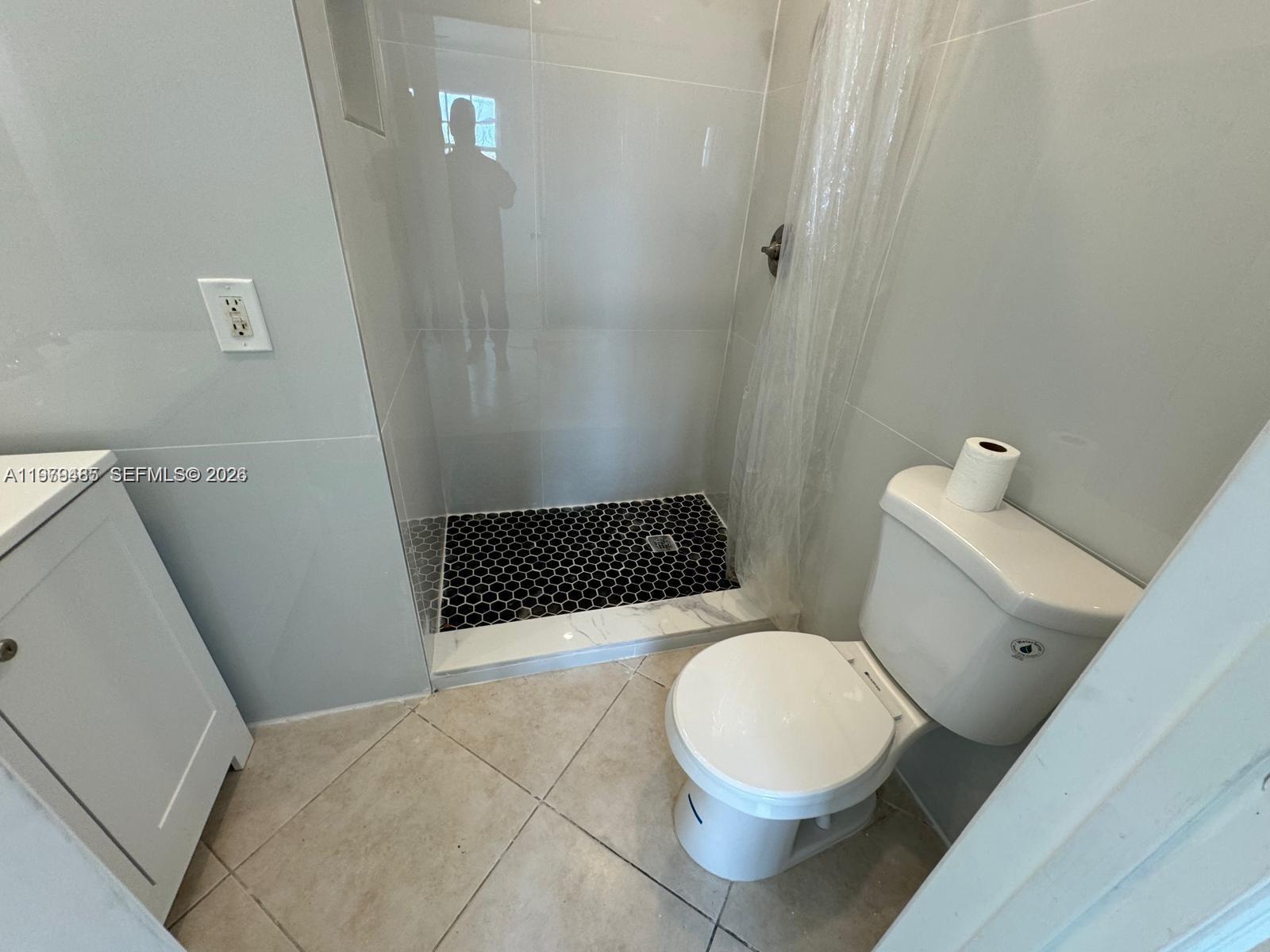 3340 Southwest 94th Place, Unit 1 Miami, FL 33165 - Photo 7 of 21 a white toilet sitting next to a shower