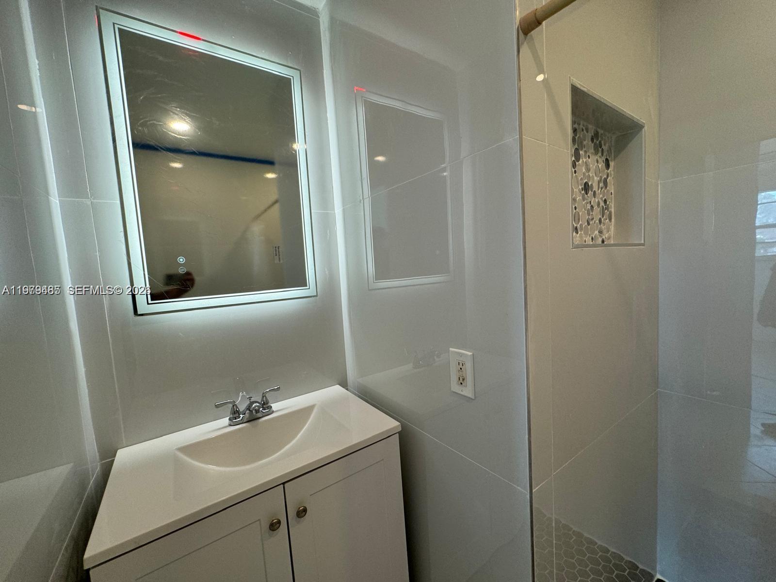 3340 Southwest 94th Place, Unit 1 Miami, FL 33165 - Photo 9 of 21 a bathroom with a sink and mirror