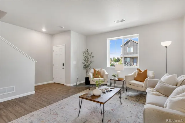 a living room with furniture and wooden floor