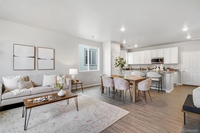 a living room with lots of furniture and kitchen view