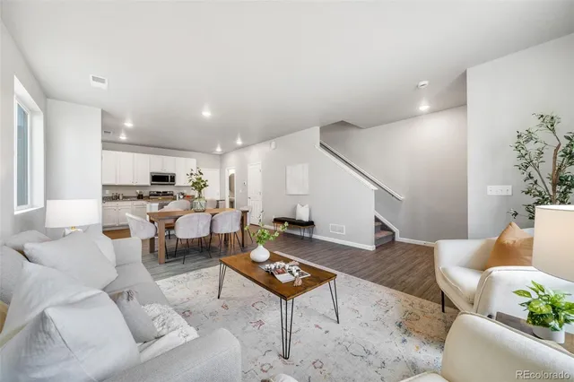 a living room with furniture kitchen view and a potted plant
