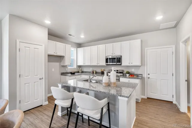 a kitchen with refrigerator and chairs