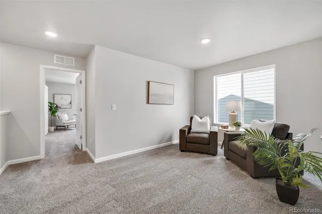 a living room with furniture and a potted plant