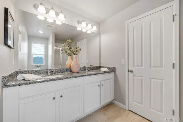 a bathroom with a double vanity sink and a mirror