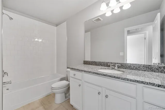 a bathroom with a granite countertop sink a toilet and bathtub