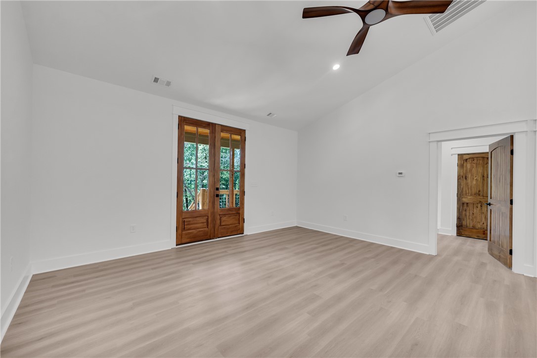 659 White Oak Farms Road Tamassee, SC 29686 - Photo 13 of 50 Double glass doors open outward from a well-proportioned bedroom with smooth wood floors.