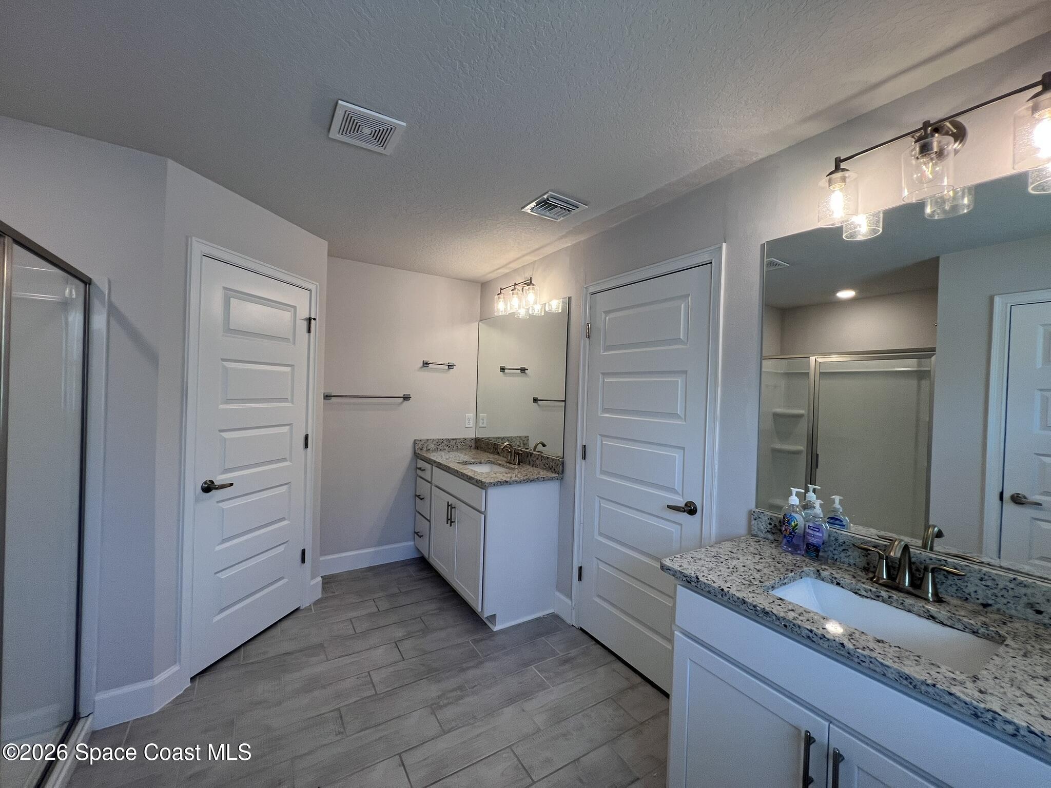 8752 Waterstone Boulevard Fort Pierce, FL 34951 - Photo 11 of 24 a large bathroom with a granite countertop sink and a mirror