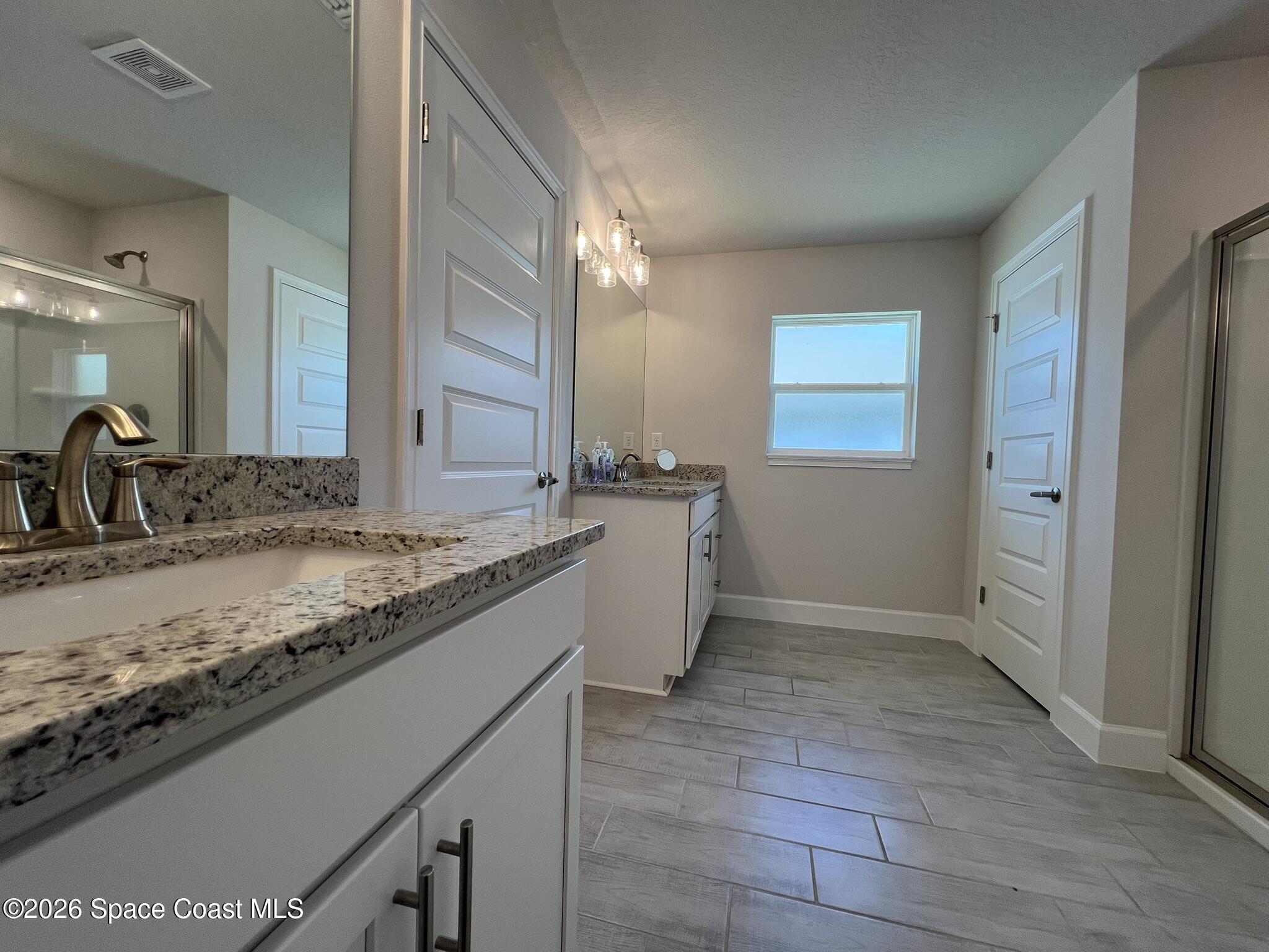 8752 Waterstone Boulevard Fort Pierce, FL 34951 - Photo 13 of 24 a bathroom with a granite countertop sink and a mirror