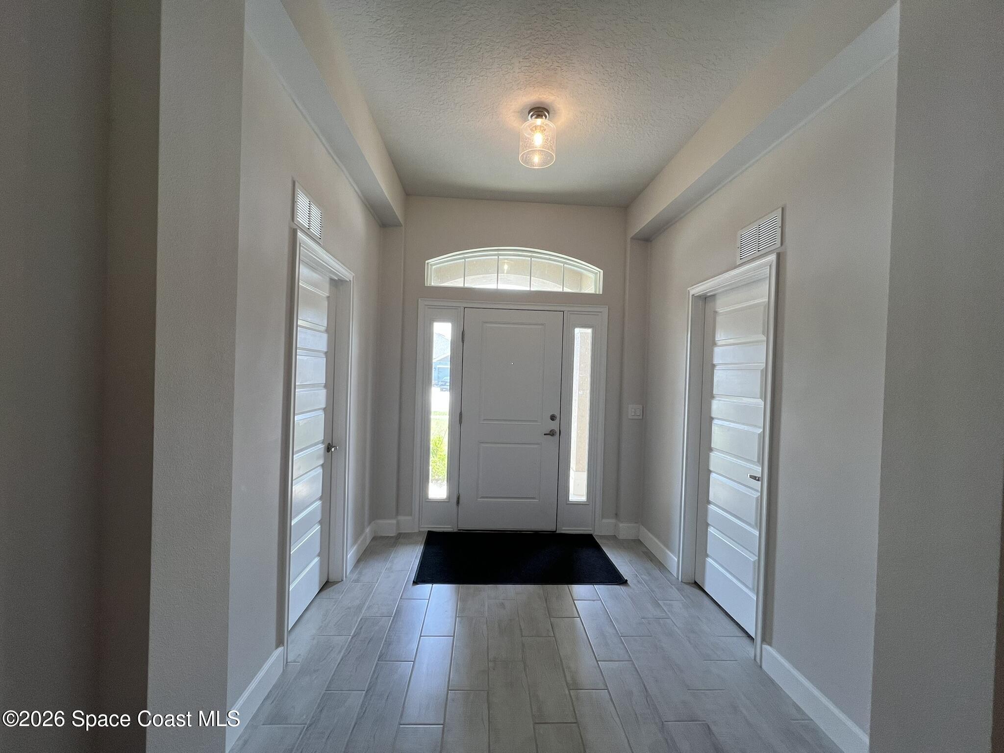 8752 Waterstone Boulevard Fort Pierce, FL 34951 - Photo 2 of 24 a view of a hallway with wooden floor and a living room
