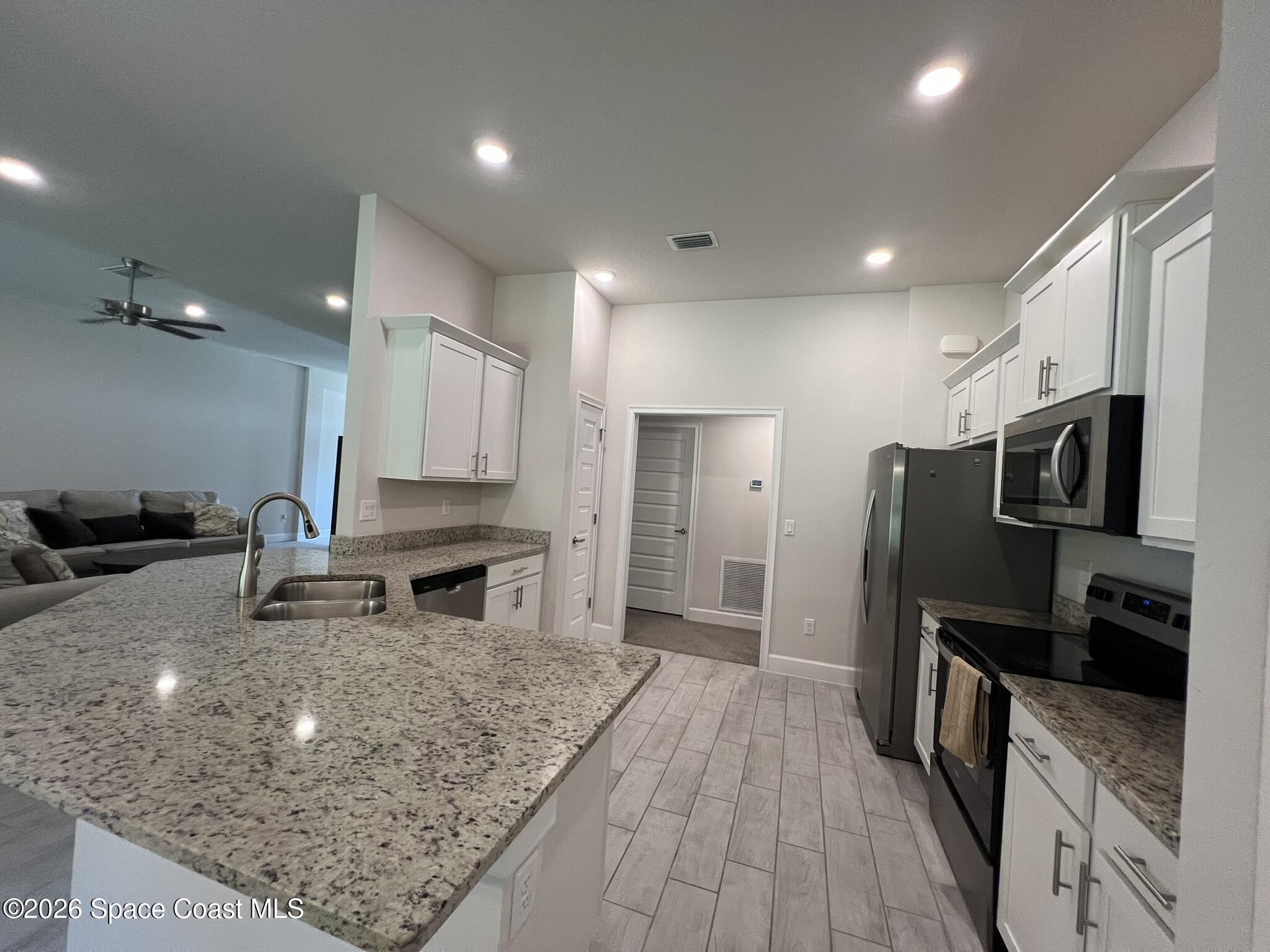 8752 Waterstone Boulevard Fort Pierce, FL 34951 - Photo 7 of 24 a kitchen with stainless steel appliances granite countertop a sink stove and refrigerator