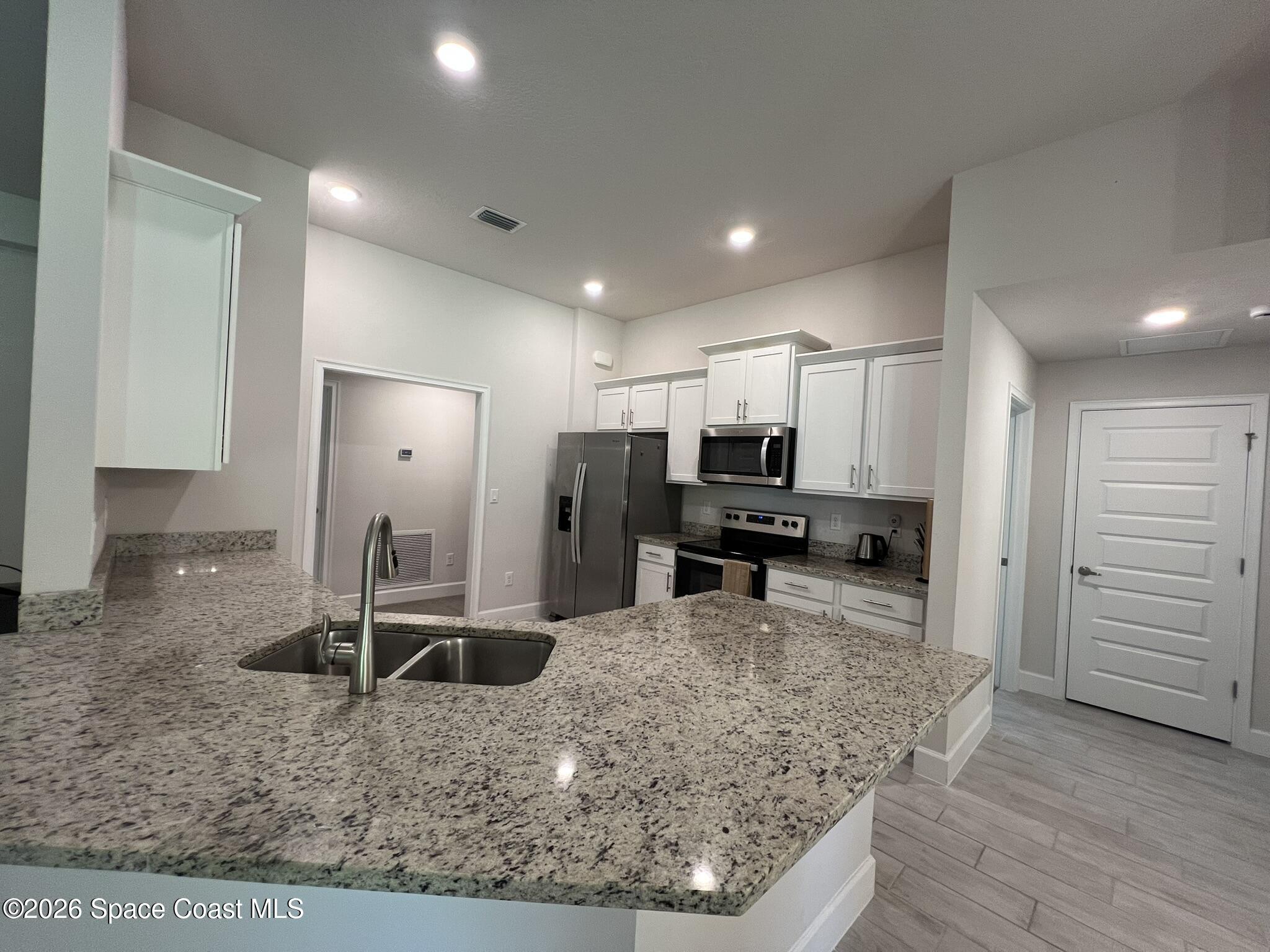 8752 Waterstone Boulevard Fort Pierce, FL 34951 - Photo 8 of 24 a kitchen with sink refrigerator and microwave