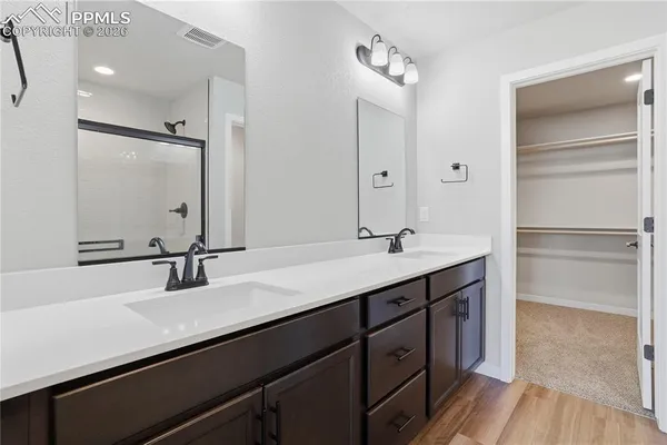 a bathroom with a double vanity sink a mirror and a shower