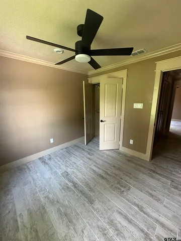 en empty room with wooden floor and windows