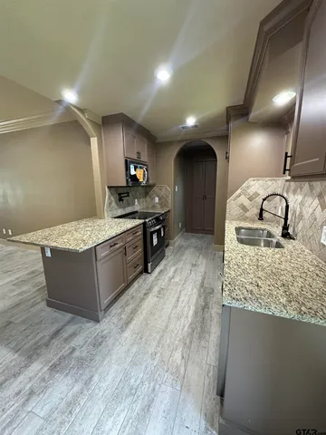 a large kitchen with kitchen island a sink stainless steel appliances and cabinets