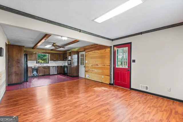 an empty room with a window and a ceiling fan