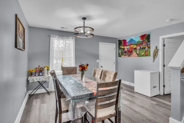 a view of a dining room with furniture wooden floor and a chandelier