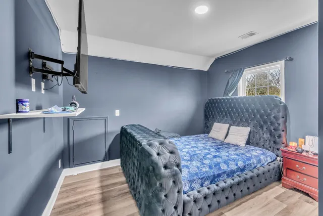 a bedroom with a large bed and a chandelier