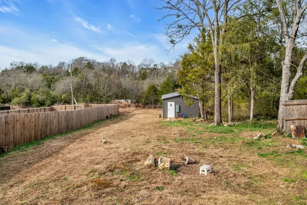 a view of a yard with wooden fence