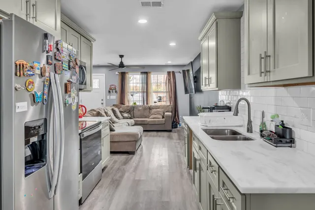a kitchen that has a lot of cabinets a sink and appliances
