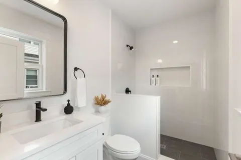 a bathroom with a sink vanity mirror and toilet
