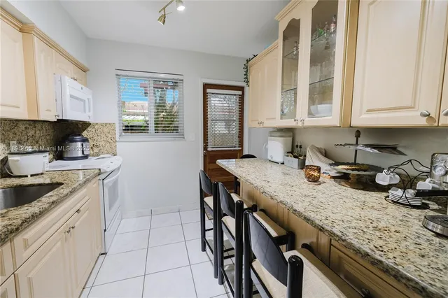 a kitchen with granite countertop a sink a stove and cabinets