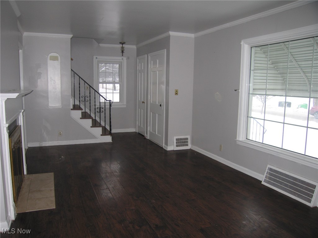 1375 Winston Road Cleveland, OH 44121 - Photo 4 of 13 Foyer featuring dark wood finished floors, crown molding, and a fireplace with flush hearth