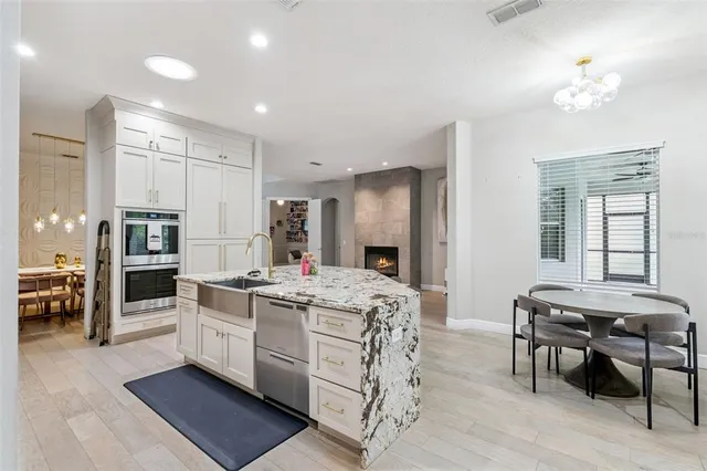 a kitchen that has a lot of cabinets in it and wooden floors
