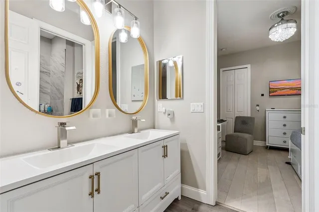 a en suite bathroom with a granite countertop sink and a mirror