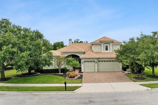 a front view of a house with a yard and trees