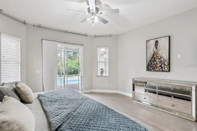 a bedroom with a bed dresser and wooden floor