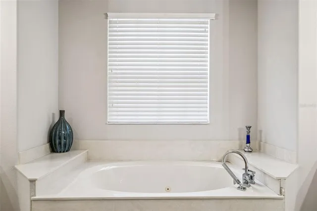 a white bath tub sitting in a bathroom next to a window