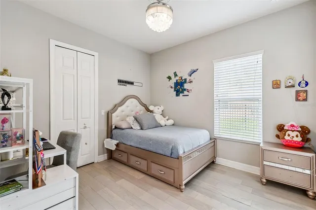 a bedroom with a bed and a chandelier