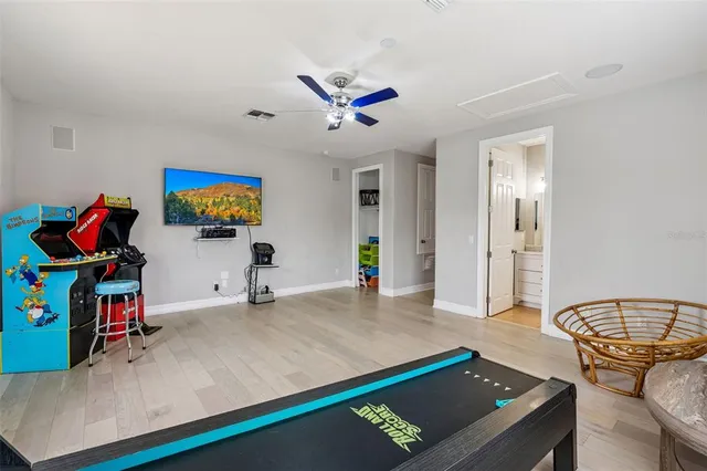 a living room with furniture pool table and flat screen tv