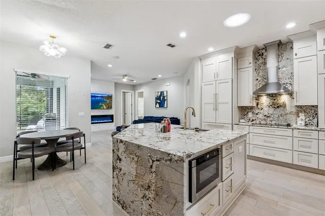 a kitchen that has a lot of cabinets in it and wooden floors