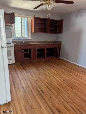a room with stainless steel appliances wooden floor and chandelier