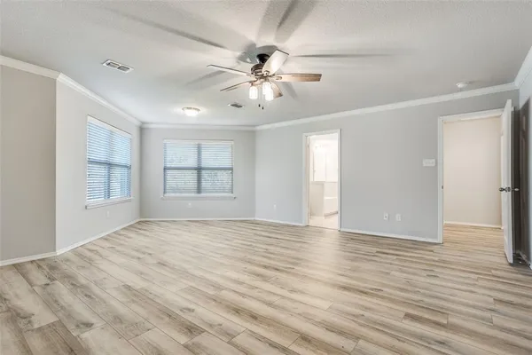 a view of an empty room with window and wooden floor