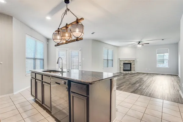 a kitchen with kitchen island granite countertop a sink cabinets and window