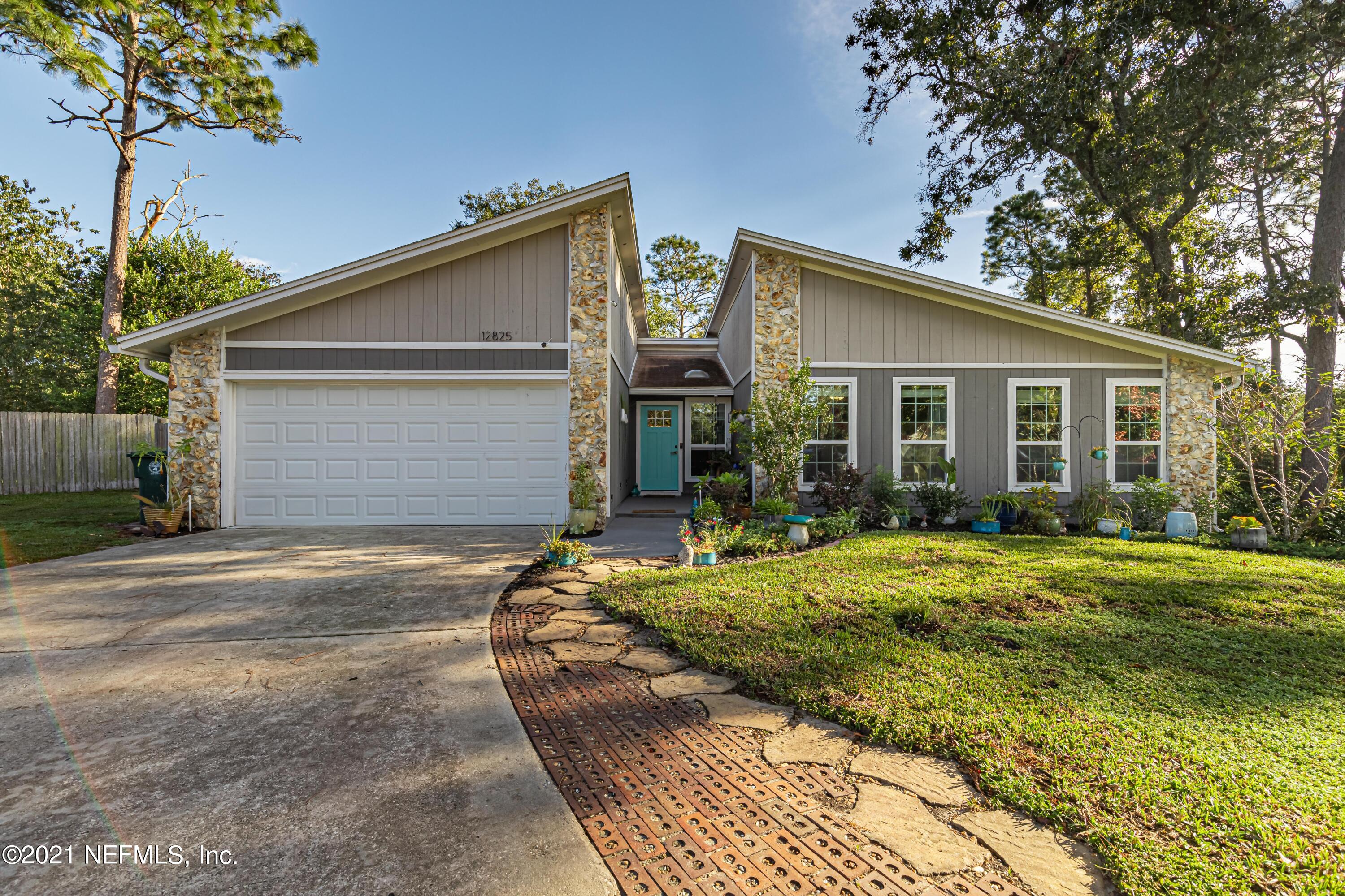 a front view of house with yard and trees around