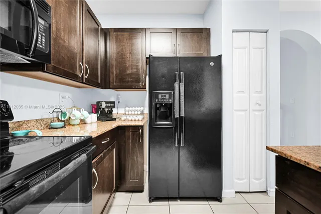 a kitchen with stainless steel appliances granite countertop a refrigerator and a stove