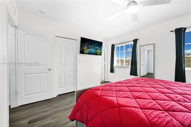a bed sitting in a spacious bedroom with a bed and a flat screen tv