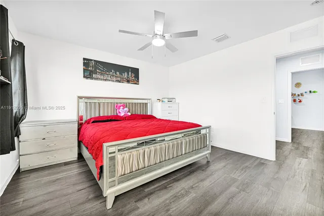 a bedroom with a bed and a ceiling fan