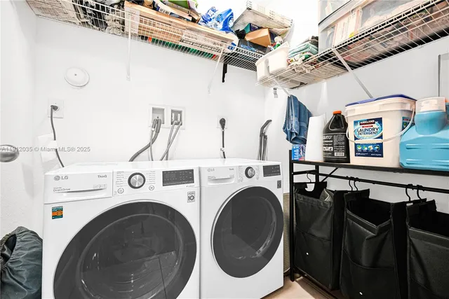 a utility room with dryer washer and stair
