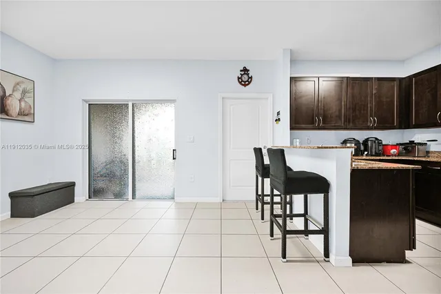 a kitchen with stainless steel appliances kitchen island granite countertop a refrigerator and a stove top oven