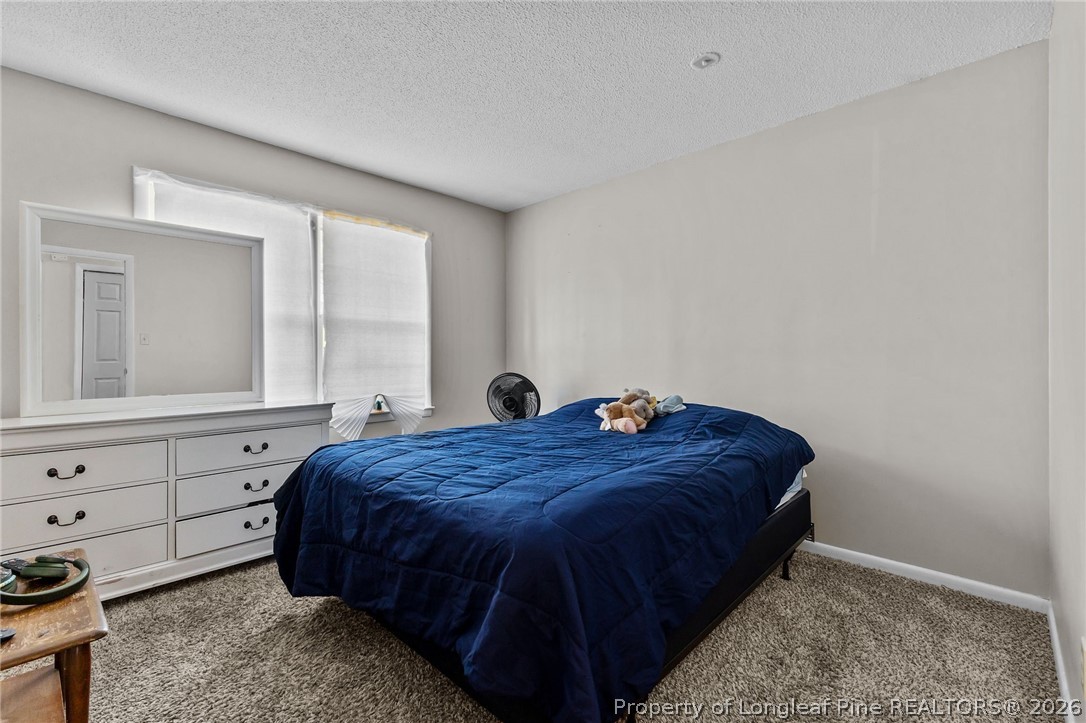 908 Ruton Court Fayetteville, NC 28303 - Photo 22 of 29 a bed sitting in a bedroom next to a window and dresser